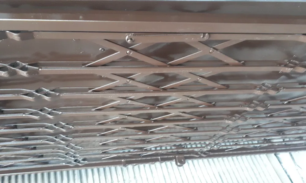 نمای باز و جمعشده حفاظ آکاردئونی فلزی پشت درب ورودی