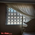 حفاظ آکاردئونی تمام گل (تمام لوزی) نصب شده بروی پنجره از داخل